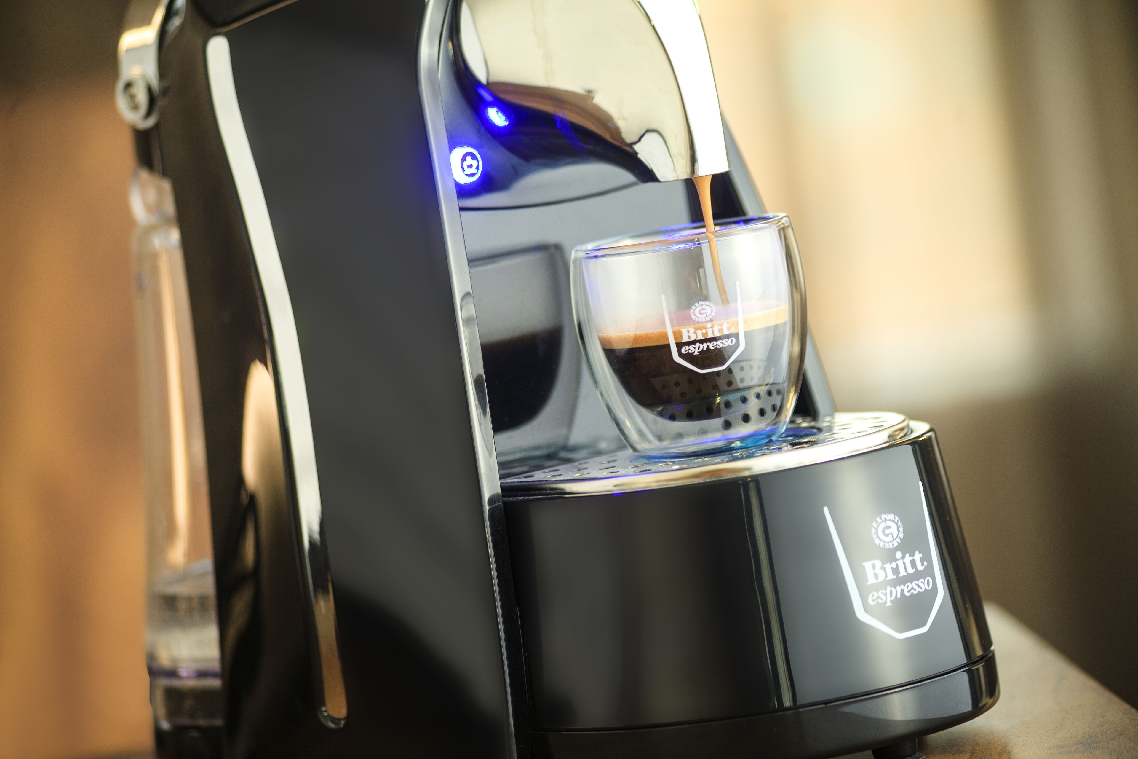 A coffee machine with a glass cup and a label that reads "Britt espresso."