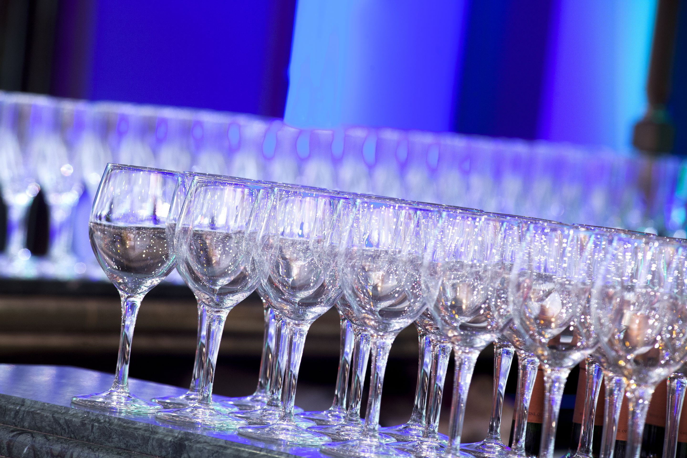 Una hilera de copas de vino vacías sobre una superficie de mármol.