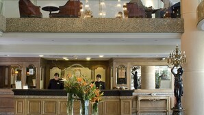 A grand lobby with a large chandelier, a reception desk, and a statue. - Regal Pacific Hotel Santiago (Santiago)