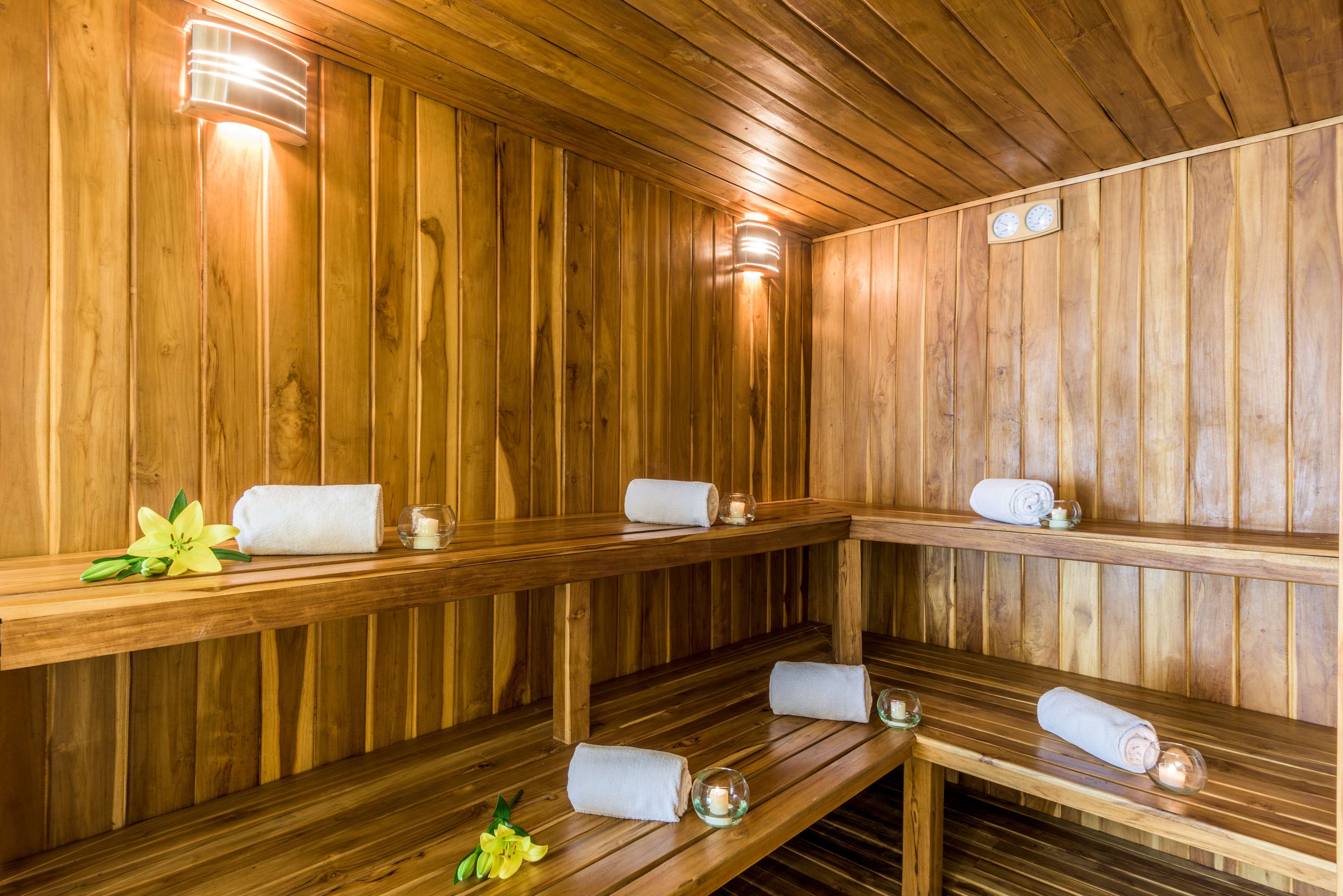 Una sauna de madera con bancos, toallas y velas.