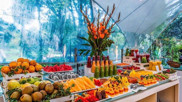 A fruit and juice display with various fruits and beverages. - NH Collection Bogotá Teleport Royal (Bogotá)