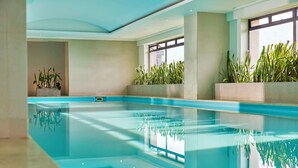 An indoor swimming pool with clear water, surrounded by walls and windows. - NH Collection Bogotá Teleport Royal (Bogotá)