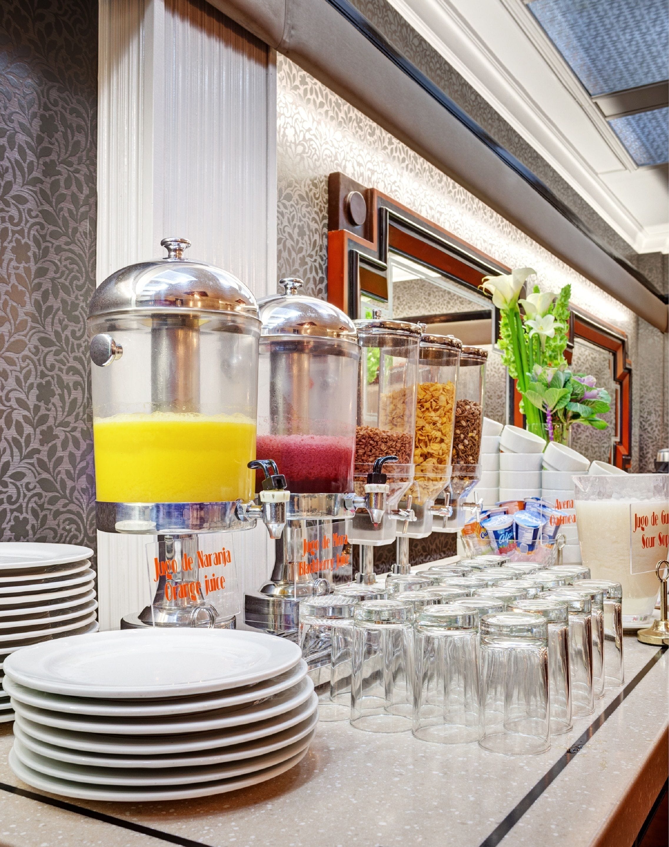 A buffet setup with various drink dispensers and food containers.