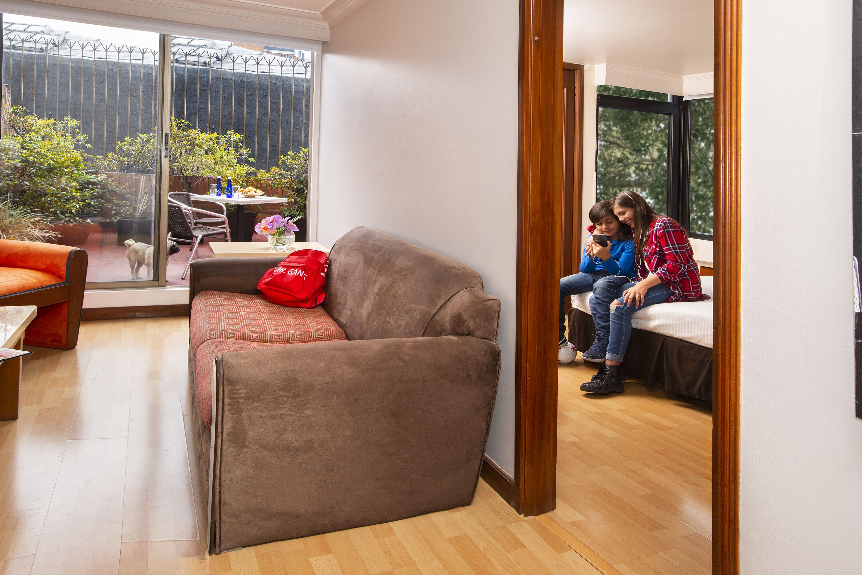 Una sala de estar moderna con un sofá, una mesa de comedor y un ventanal grande.