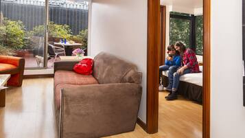 Una sala de estar moderna con un sofá, una mesa de comedor y un ventanal grande.
