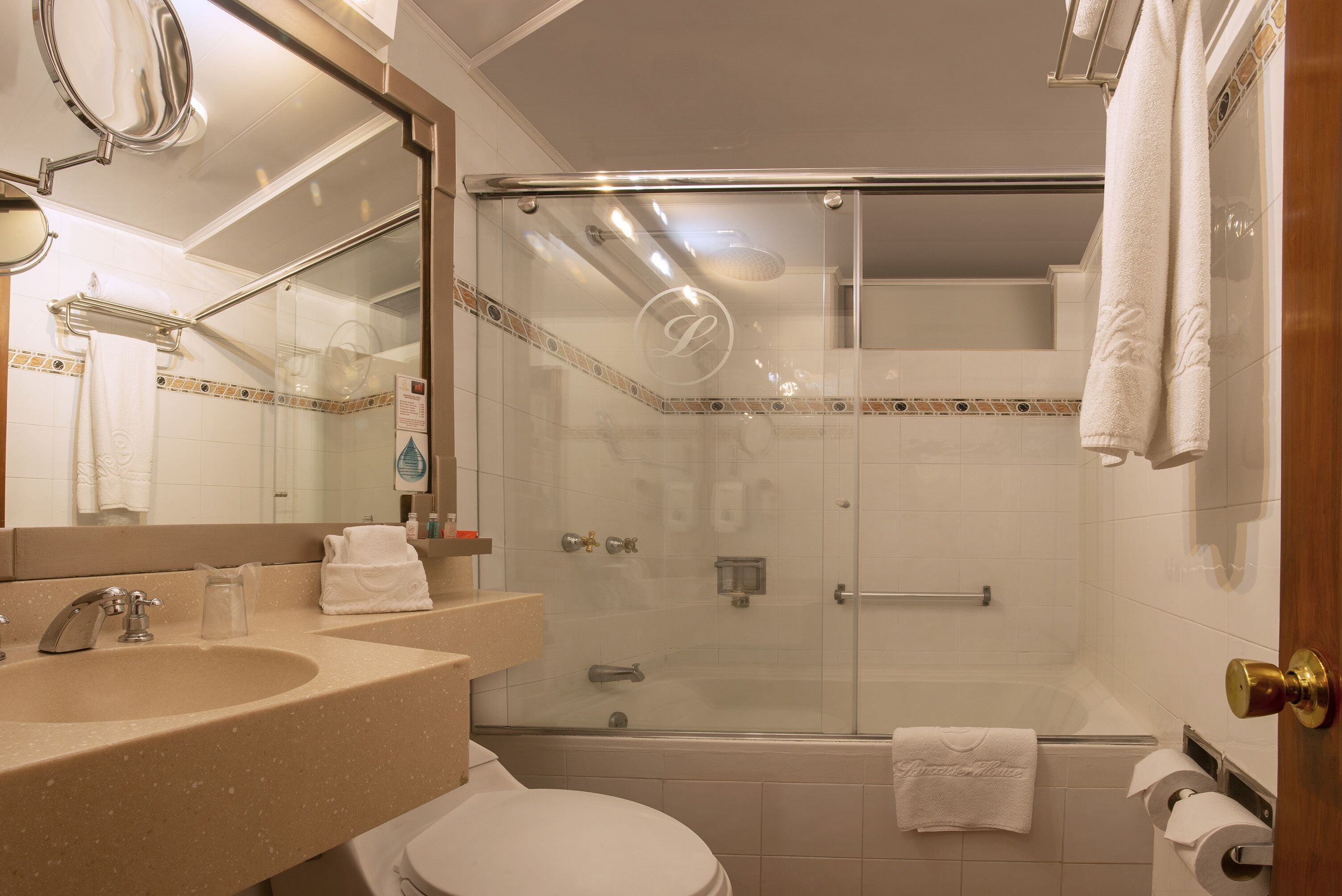 A modern bathroom with a glass-enclosed shower, a sink with a mirror, and a toilet.