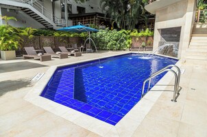 Una piscina al aire libre, sombrillas