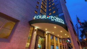 L’entrée d’un hôtel, avec une enseigne indiquant : « FOUR POINTS BY SHERATON ».