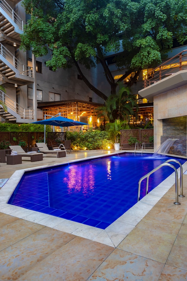 Una piscina al aire libre, sombrillas