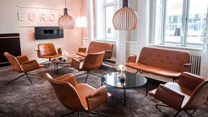 A modern lounge area with a sofa, chairs, and a coffee table. - Hotel Europa (Aabenraa)