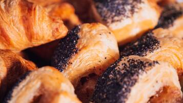 A close-up of various pastries, including croissants and poppy seed rolls.
