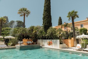 Una piscina al aire libre de temporada, sombrillas