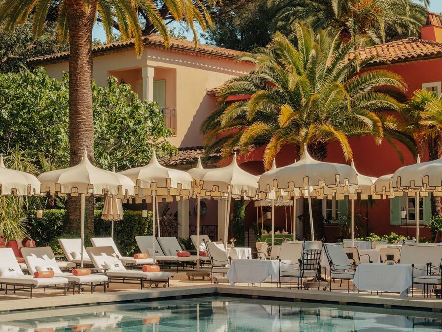 Una piscina al aire libre de temporada, sombrillas, tumbonas