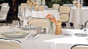 Outdoor dining tables with white tablecloths, chairs, and umbrellas. - La Bastide de Saint Tropez (Saint-Tropez)