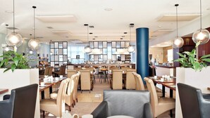 A modern dining area with high tables, comfortable seating, and pendant lighting. - Courtyard by Marriott Dresden (Dresden)