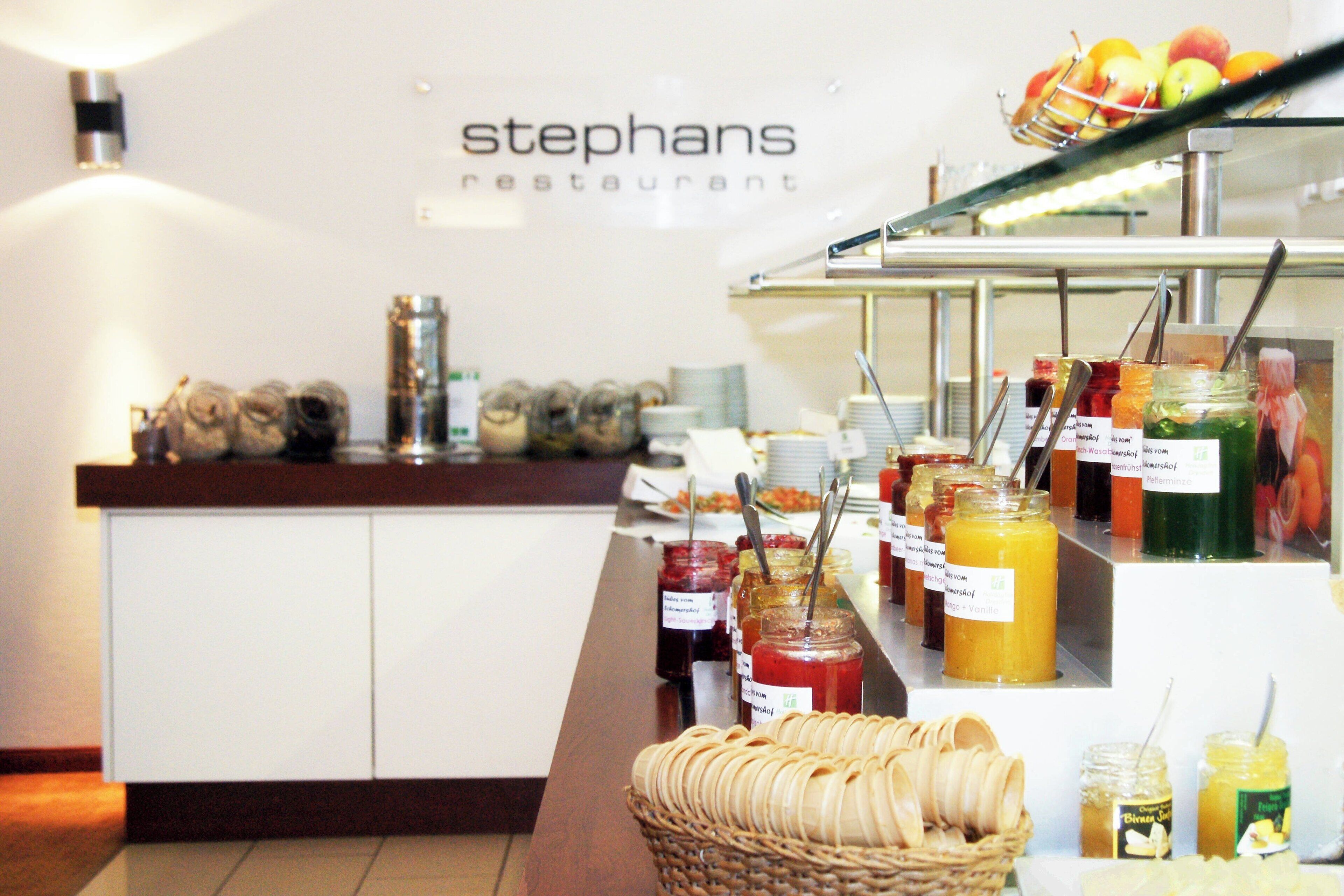 A buffet counter with various food items and condiments.