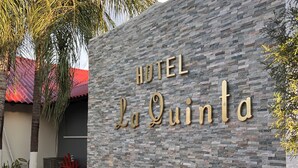 A stone wall with the text "HOTEL La Quinta" in gold lettering. - La Quinta Hotel (La Ceiba)