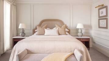 Une chambre bien rangée, avec un grand lit, deux tables de chevet et une chaise.