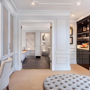 A modern bathroom with a marble vanity, a bathtub, and a shower area.