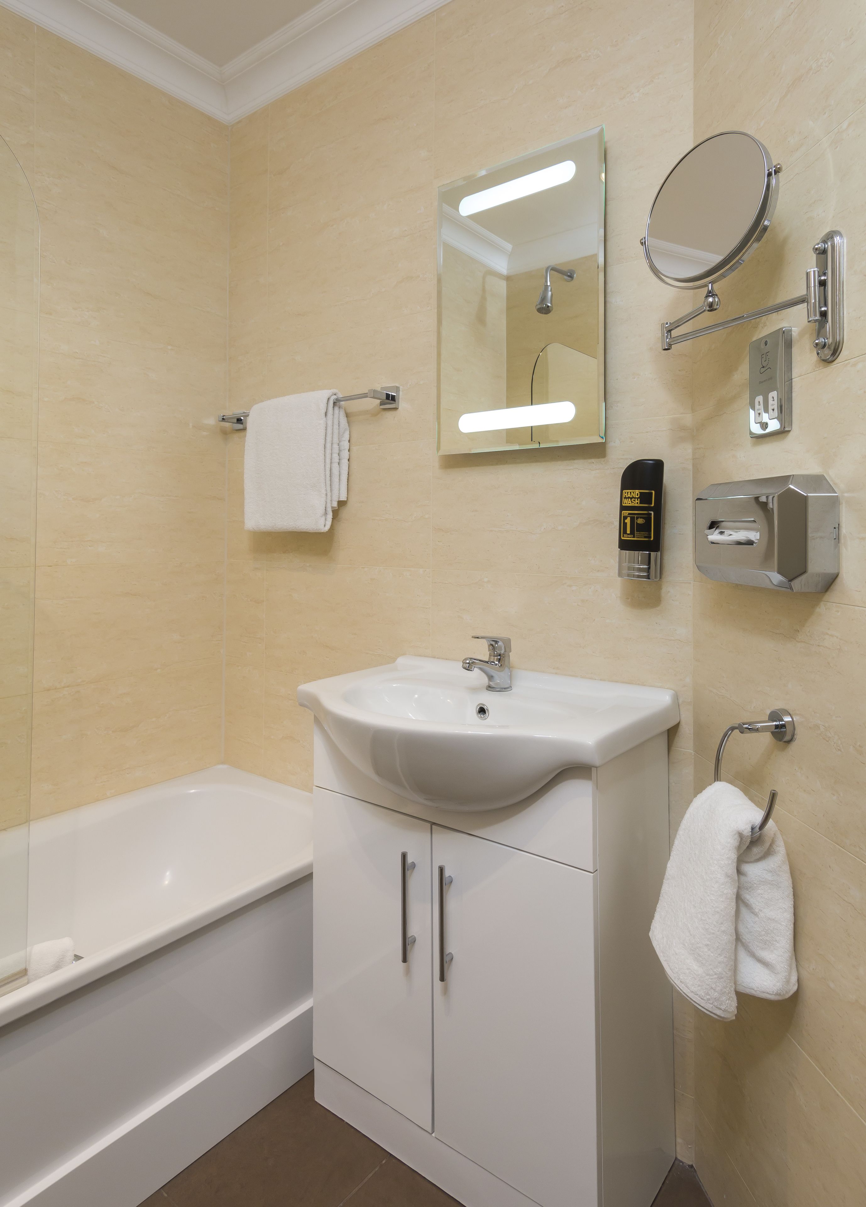 A bathroom with a white sink, a mirror, a hand dryer, and a towel rack.