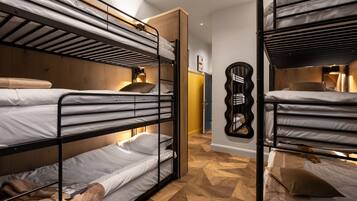 A room with bunk beds, wooden paneling, and a mirror on the wall.