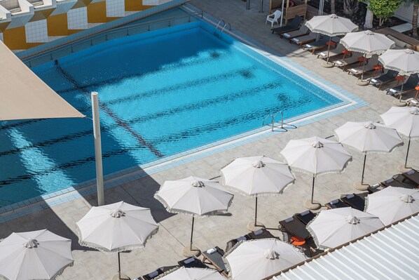A swimming pool with multiple lounge chairs and umbrellas. - Neve Eilat Hotel (Nova Hotel) By Atlas Hotels (Eilat)