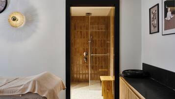Ein modernes Badezimmer mit einer Duschkabine aus Holz, einer Sitzbank und einer schwarzen Arbeitsplatte.