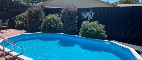 Una piscina al aire libre de temporada, sillones reclinables de piscina