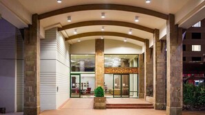 A hotel entrance with a curved archway, glass doors, and a central decorative panel. - Novotel Rotorua Lakeside (Rotorua)