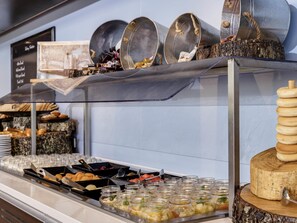 A buffet with various food items, including pastries and jars of pickles. - Novotel Rotorua Lakeside (Rotorua)