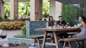 A patio with stone walls, a wooden table, and a bench.