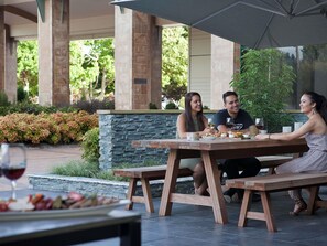 A patio with stone walls, a wooden table, and a bench.