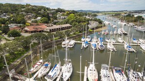 A marina with numerous boats docked, surrounded by residential buildings and greenery. - Distinction Whangarei Hotel & Conference Centre (Whangarei)