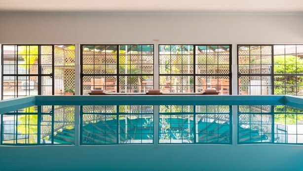 A pool area with a view of a garden through a lattice window. - Distinction Whangarei Hotel & Conference Centre (Whangarei)
