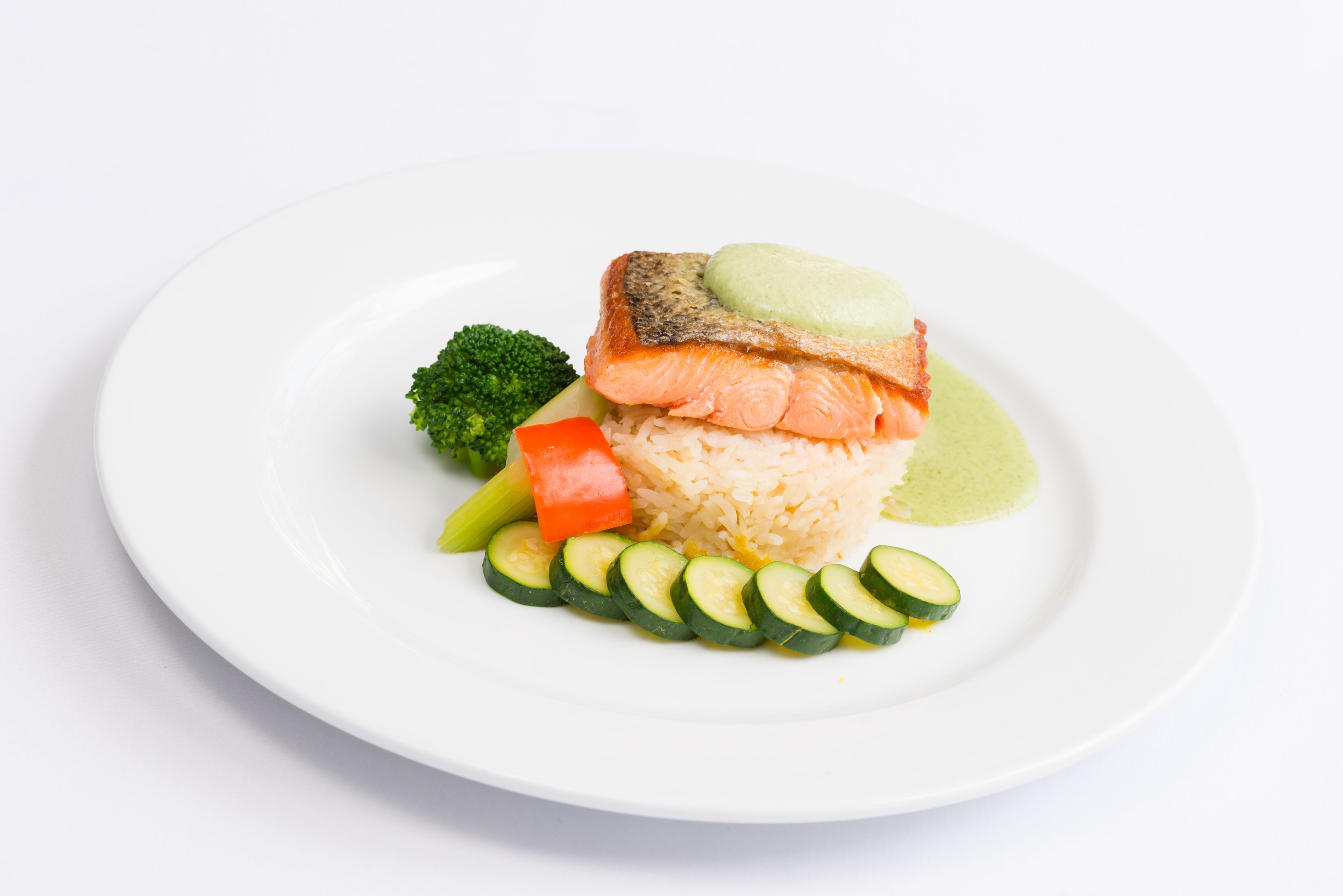 A plate with salmon, rice, and vegetables.