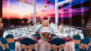 A formal dining setup with tables arranged in a semi-circle, large windows, and chandeliers. - Howard Plaza Hotel Kaohsiung (Kaohsiung)
