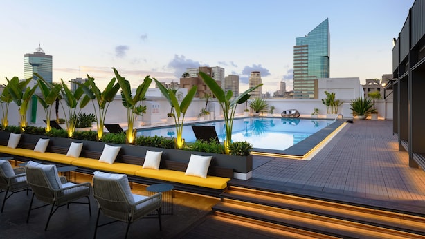A rooftop pool area with seating and plants, surrounded by city buildings. - Howard Plaza Hotel Kaohsiung (Kaohsiung)