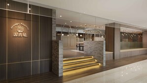 A modern hotel lobby with a wooden reception desk, a staircase with illuminated steps, and a seating area with a stone wall. - Howard Plaza Hotel Kaohsiung (Kaohsiung)