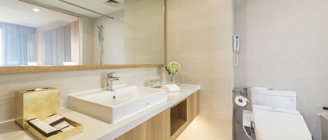 Un baño moderno con un espejo grande, dos lavamanos, un inodoro y un mueble de tocador de madera.