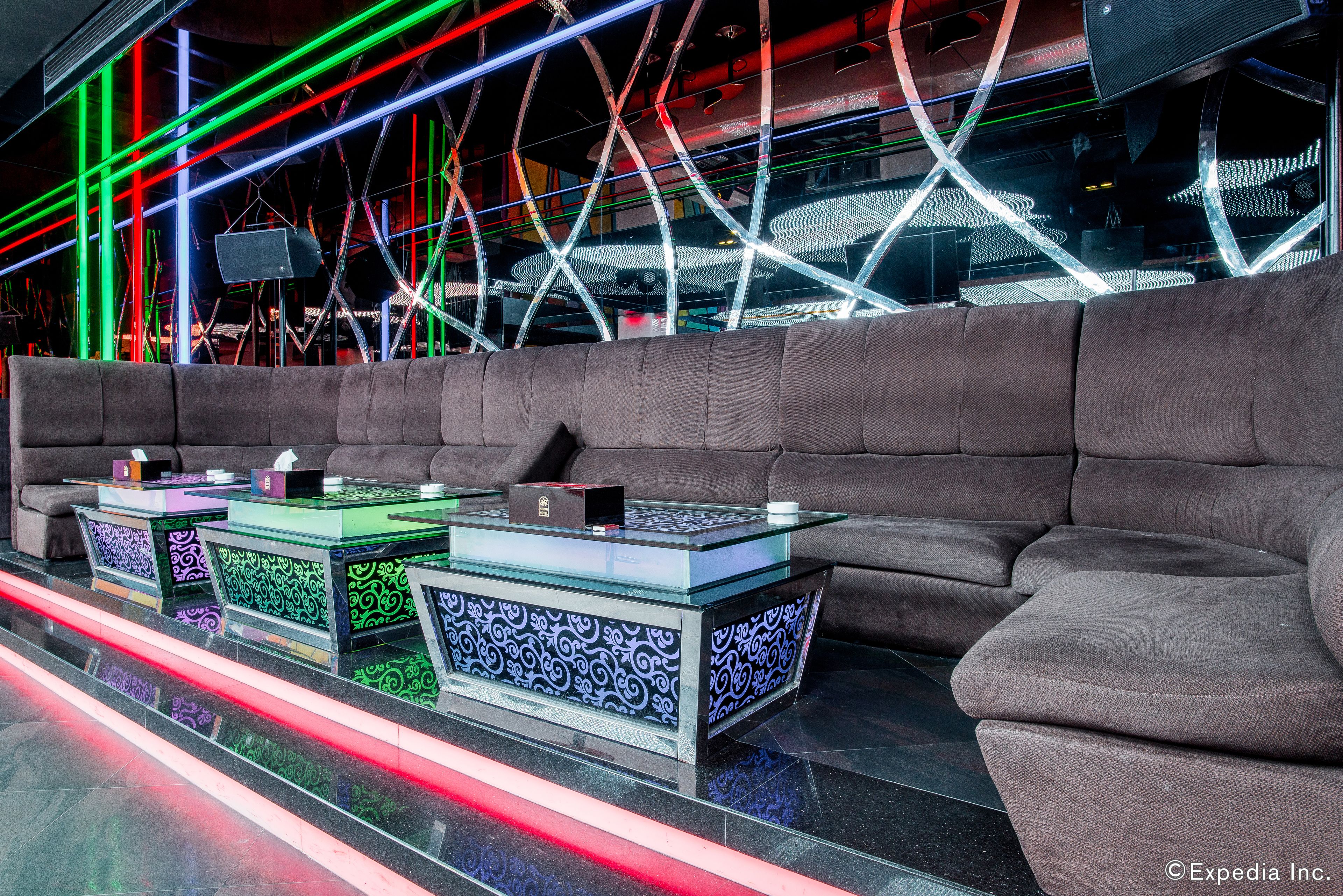 Ein moderner Lounge-Bereich mit einer Couch und Glastischen mit gemusterten Oberflächen.