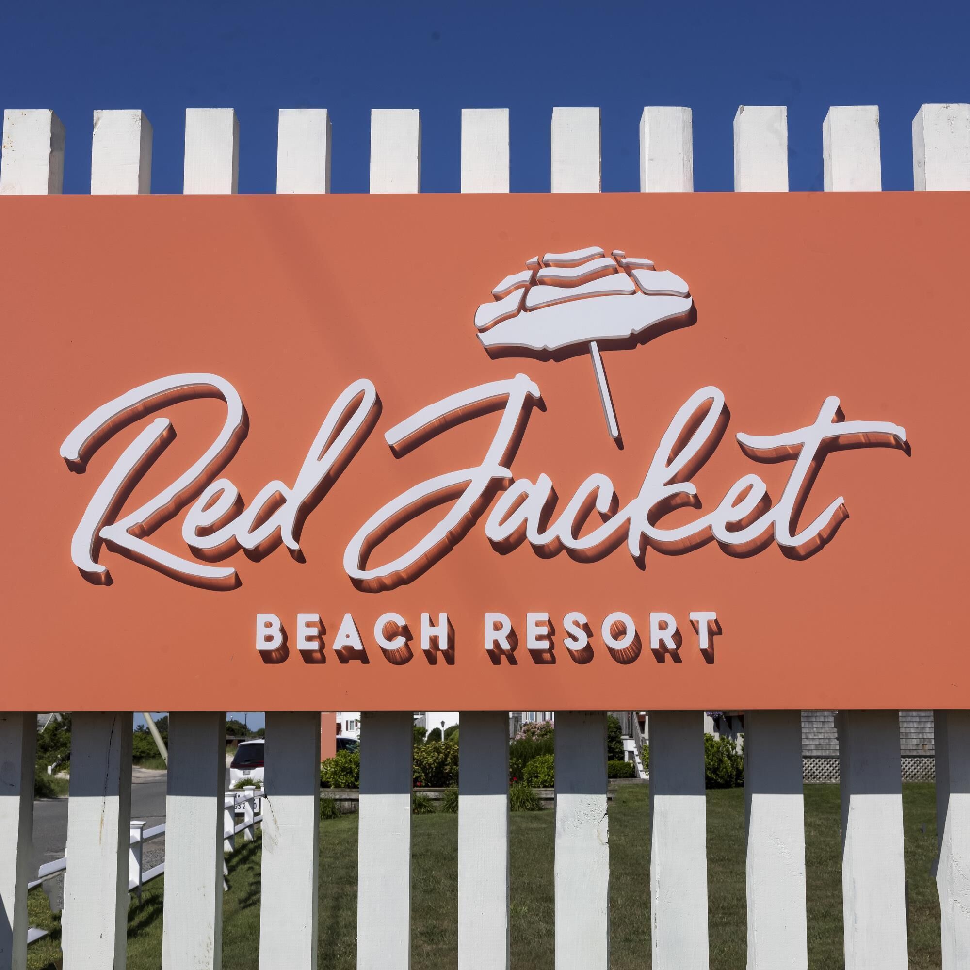 A sign for Red Jacket Beach Resort with a beach umbrella graphic.