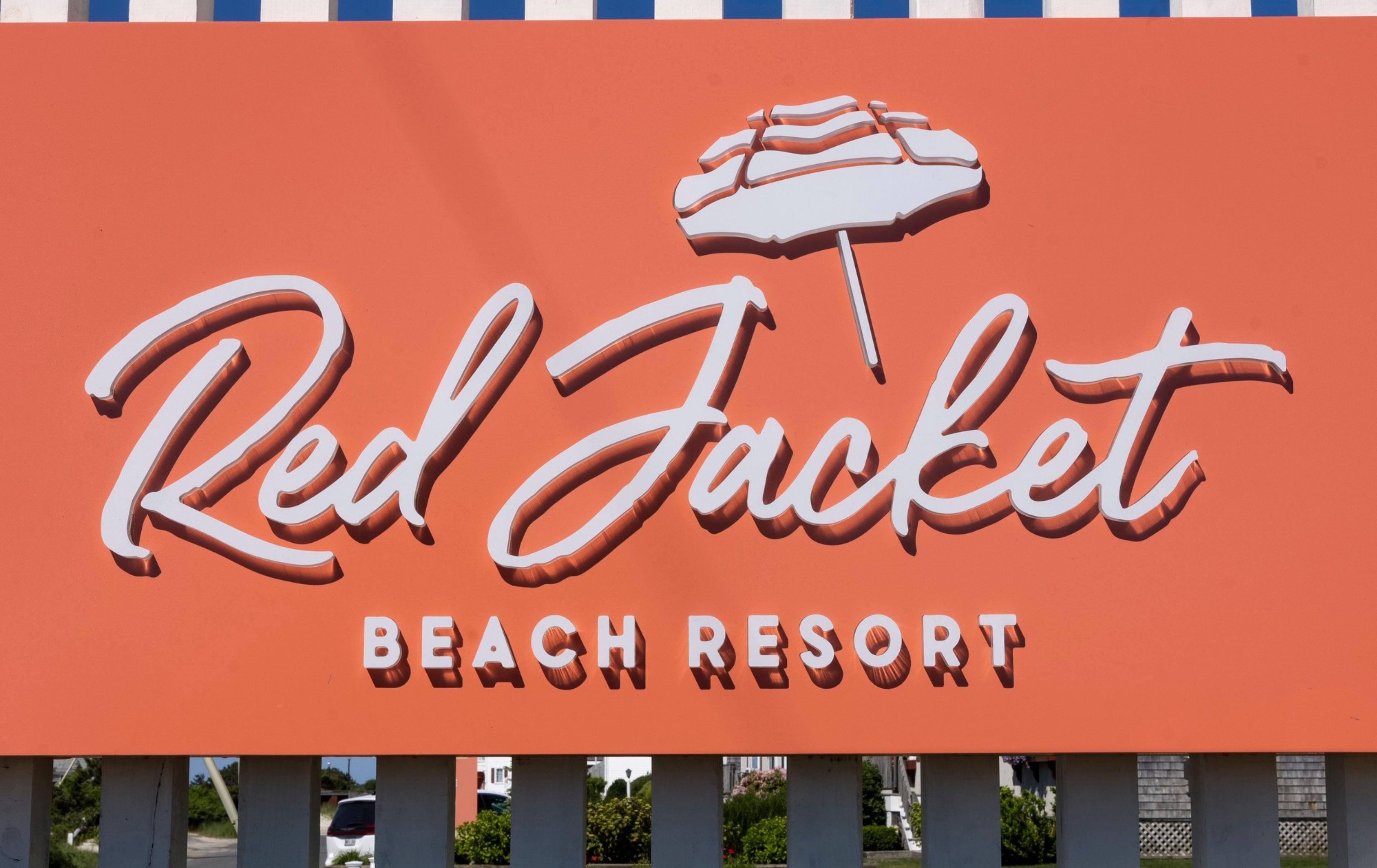 Une enseigne pour le Red Jacket Beach Resort, avec un motif de parasol stylisé.
