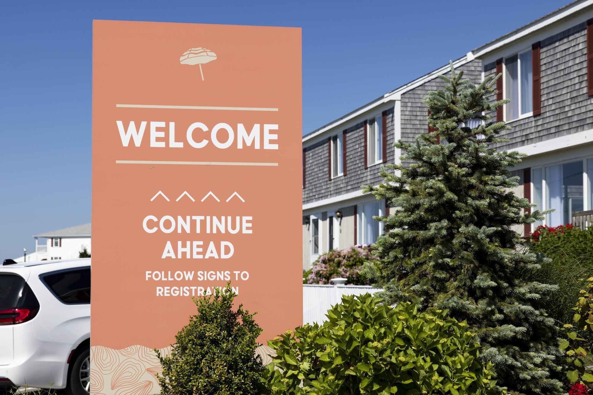 A sign with 'WELCOME' and 'CONTINUE AHEAD' text, indicating a direction for visitors.