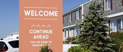 A sign with 'WELCOME' and 'CONTINUE AHEAD' text, indicating a direction for visitors.