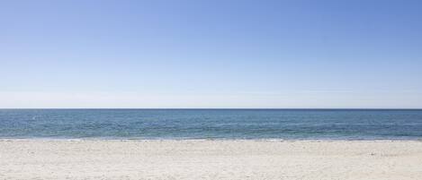 A beach with a clear sky and calm sea.