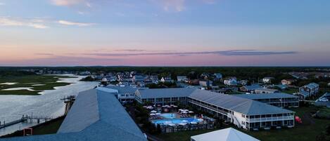 A coastal hotel with multiple buildings, a swimming pool, and a dock.