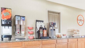 A kitchen area with a coffee machine, a refrigerator, and a coffee dispenser. - Howard Johnson by Wyndham Springfield (Springfield)