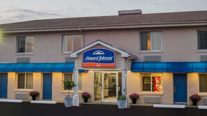 A Howard Johnson Inn with a blue awning, a prominent sign, and potted plants at the entrance. - Howard Johnson by Wyndham Springfield (Springfield)