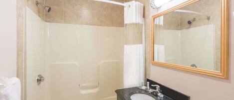 A bathroom with a glass-enclosed shower, a bathtub, and a sink with a mirror above it.