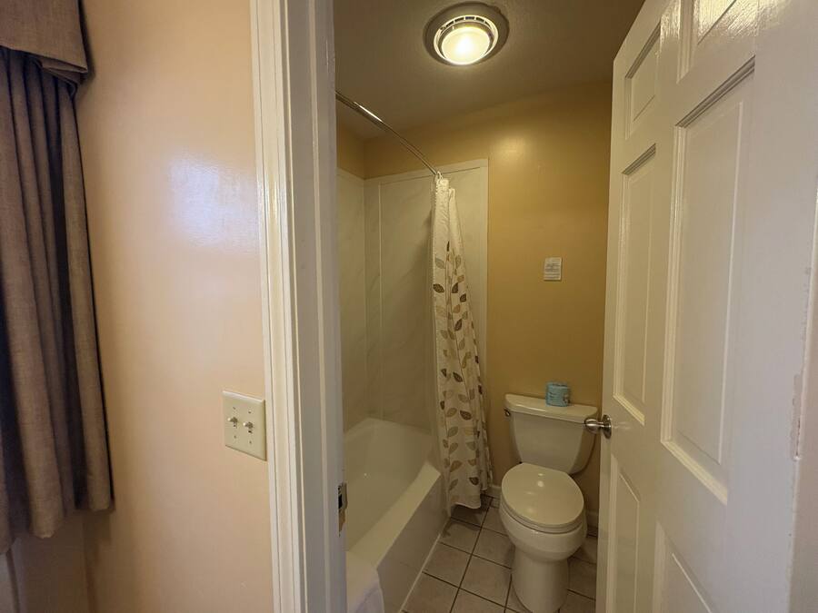 A bathroom with a toilet, shower, and a bathtub.
